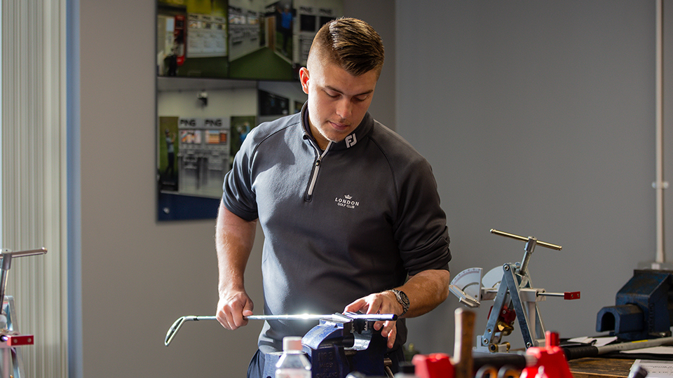 A newly qualified PGA professional re-gripping a golf club