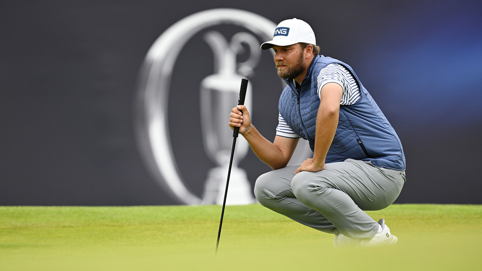 Daniel Brown of England lines up a putt on the 18th green