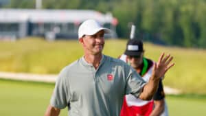 Adam Scott waves to crowd after making a birdie shot on the 14th hole with caddie, Matthew Tritton, during the third round of the 2025 U.S. Open at Oakmont Country Club