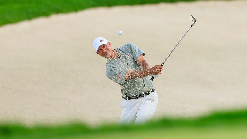 Adam Scott plays a bunker shot on the 15th hole during the third round