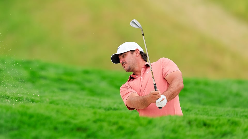 Brooks Koepka plays a bunker shot on the fifth hole during a practice round