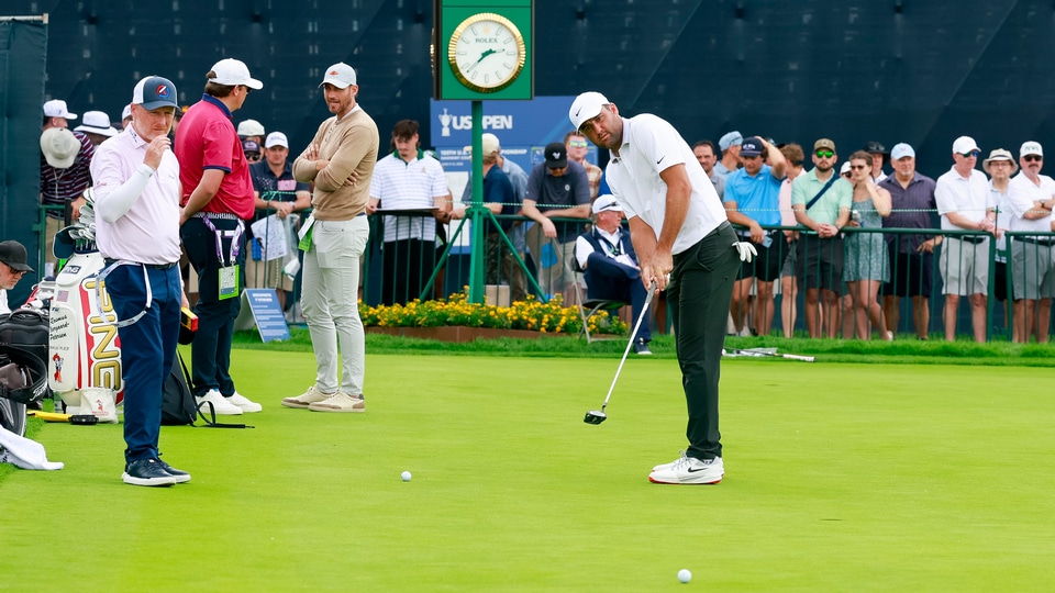 Scottie Scheffler putts in the practice area